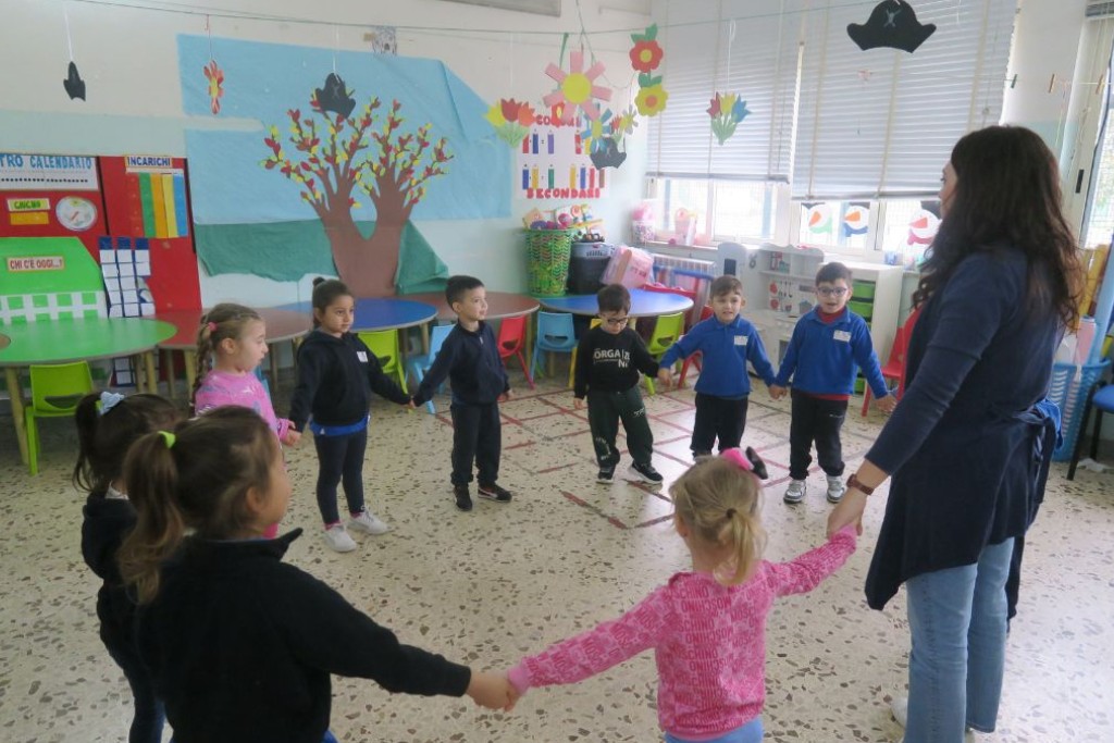 foto bambini in cerchio insieme a educatrice