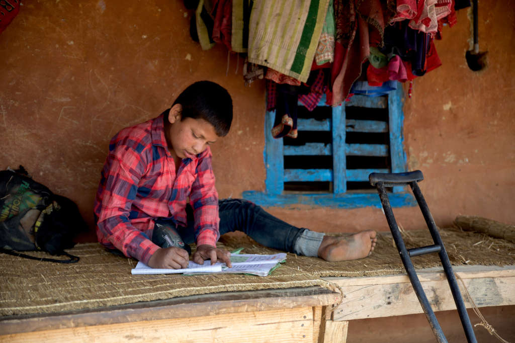 Naresh fa i compiti seduto davanti a casa