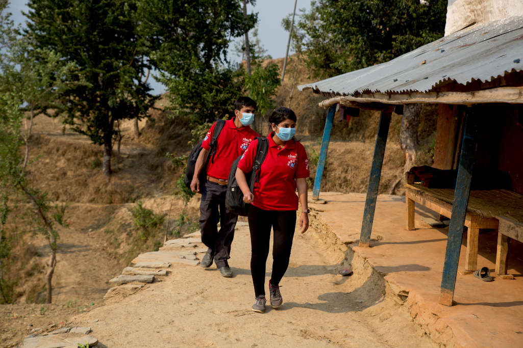 Operatori con maglia rossa CBM si avvicinano all’ingresso della casa