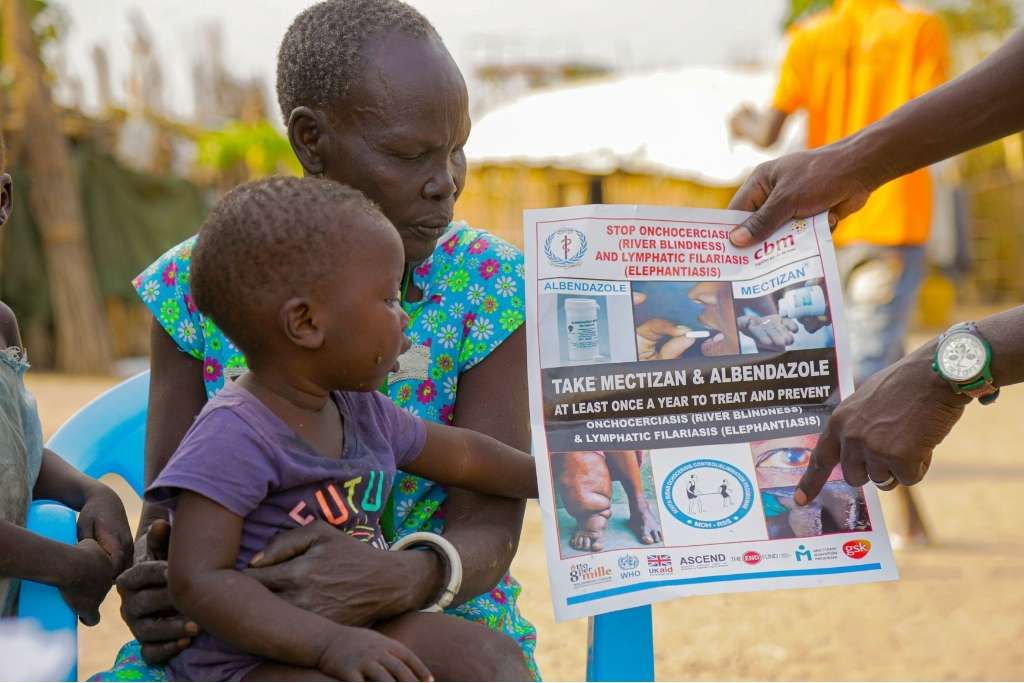 donna con bambino, operatore illustra materiali sensibilizzazione